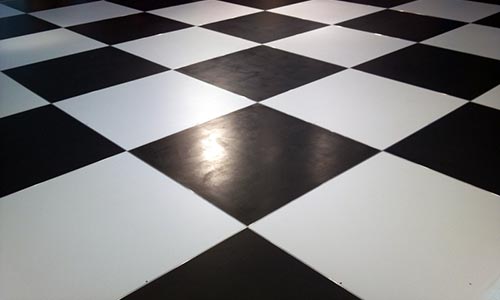 Photo of a closeup of a black and white checkered portable dance floor. 