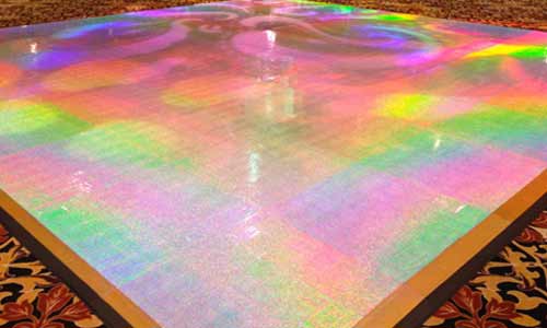 Photo of portable holographic dance floor. It has a light rainbow sheen with gold trim.