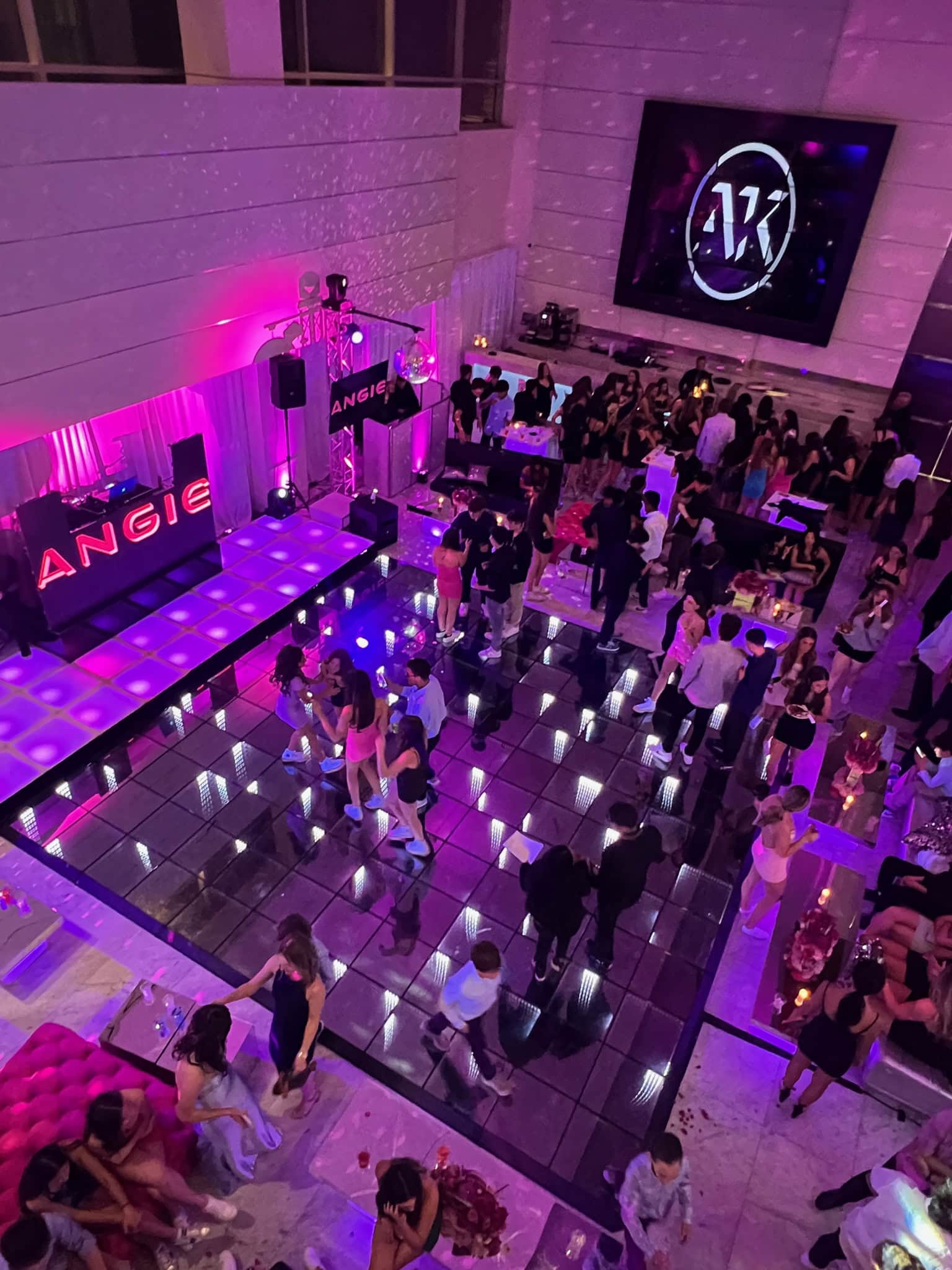 Sweet sixteen party in New York & Long Island with dancing, vibrant lights, and a screen showing "AK".